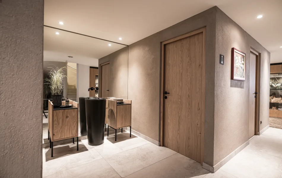 Waschraum mit Scheibenputz in hellem braun, raumhoher Spiegel, Waschtische davor.